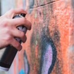 man-s-hand-drawing-graffiti-wall-with-aerosol-can
